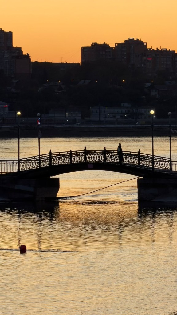 Irkutsk’ta gün batımında Angara Nehri ve yaya köprüsü