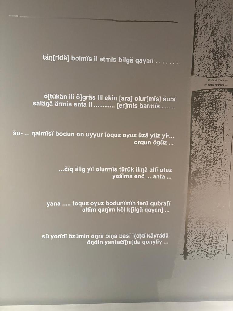 Müzedeki eski Türkçe yazıt metninin Latin harfleriyle aktarımı ve sağdaki yazıt görüntüsü